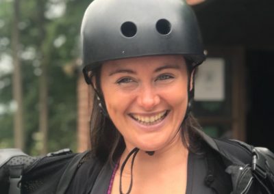 A woman smiling with a helmet on